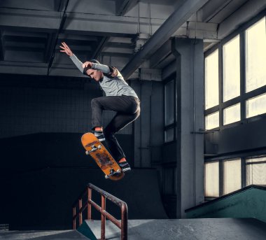 Genç kaykaycı mini rampa skate park kapalı bir numara performans. 