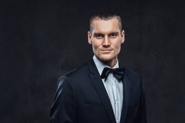 Yakışıklı şık giyen zarif klasik takım elbise bir papyon ile portresi.