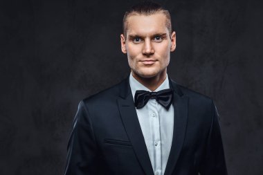 Yakışıklı şık giyen zarif klasik takım elbise bir papyon ile portresi.