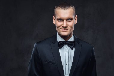 Yakışıklı şık giyen zarif klasik takım elbise bir papyon ile portresi.