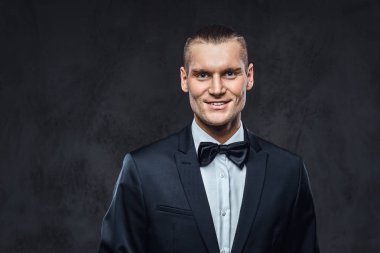 Yakışıklı şık giyen zarif klasik takım elbise bir papyon ile portresi.