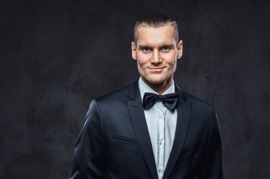 Yakışıklı şık giyen zarif klasik takım elbise bir papyon ile portresi.