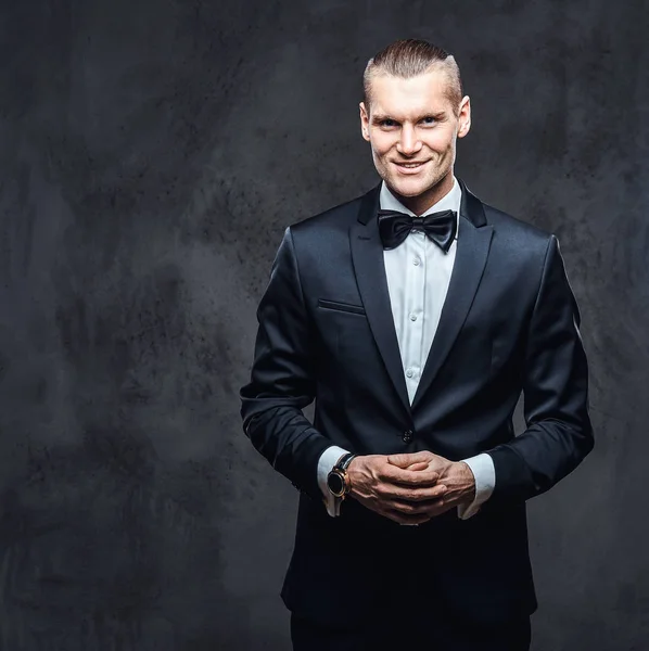 Portrait of a handsome stylish wearing elegant classical suit with a bow tie. — Stock Photo, Image