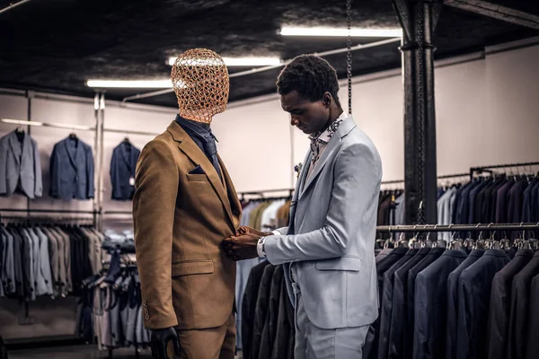 Homem afro-americano elegantemente vestido trabalhando na loja de moda masculina clássica . — Fotografia de Stock