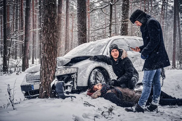 Witness of the accident helps the injured couple to contact the rescue service. — Stock Photo, Image
