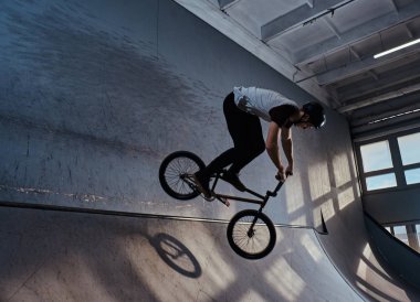 Bmx hileci skatepark kapalı performans ile genç adam
