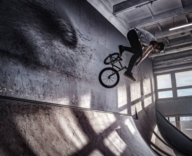 Genç Bmx Bisiklet kapalı skatepark içinde deli hileler yapma.