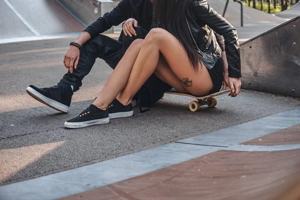 Néhány szerelmes együtt egy gördeszka, skate park ül a nyáron — Stock Fotó