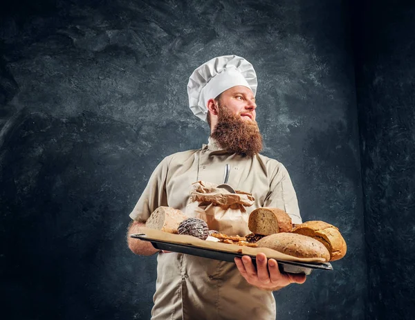 Noszenie taca uniform gospodarstwa ze świeżych produktów z jego piekarnia piekarz — Zdjęcie stockowe