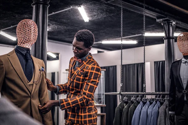 Afrikanisch-amerikanischer Mann im trendigen eleganten Anzug, der in einem klassischen Herrengeschäft arbeitet. — Stockfoto