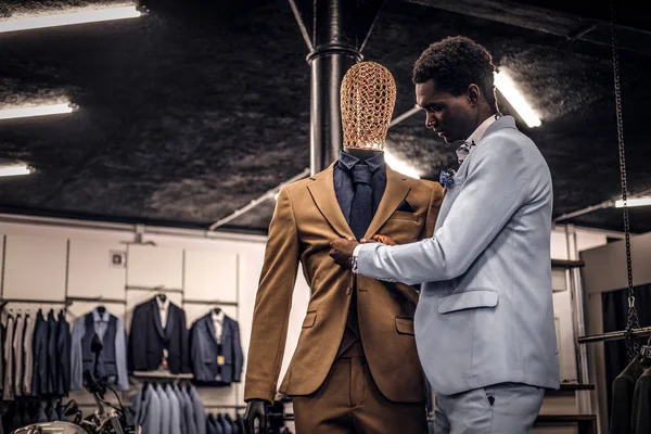 Elegant klädd afroamerikansk man som arbetar på klassiska herrkläder butik. — Stockfoto