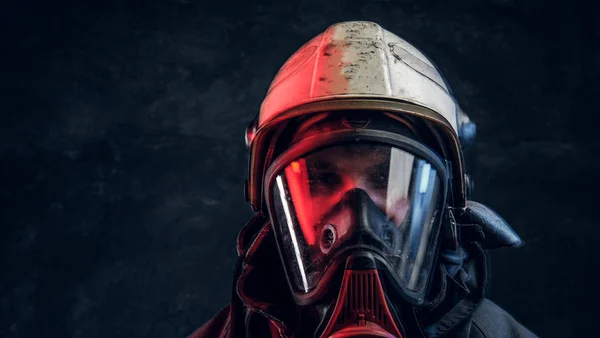 Bombero brutal en máscara de gas y casco mira a la cámara — Foto de Stock