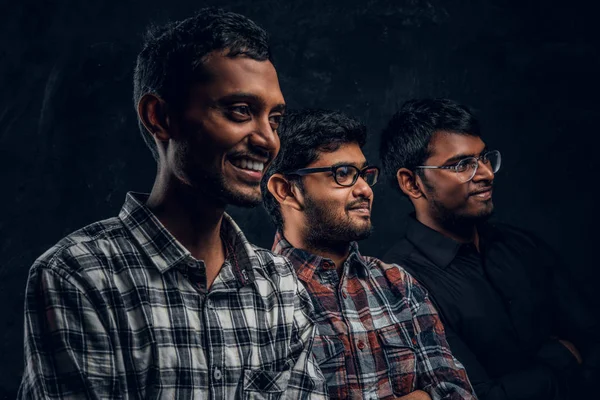 Karanlık bir duvara rahat kıyafetler giyen üç mutlu Hint öğrenci portresi yakın çekim. — Stok fotoğraf