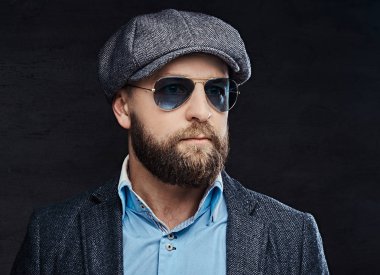 Yakın çekim giyen bir bere ve ceket, beyaz arka plan üzerinde izole güneş gözlüğü başarılı bir şık adam portresi