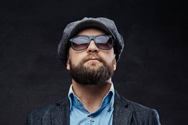 Yakın çekim giyen bir bere ve ceket, beyaz arka plan üzerinde izole güneş gözlüğü başarılı bir şık adam portresi