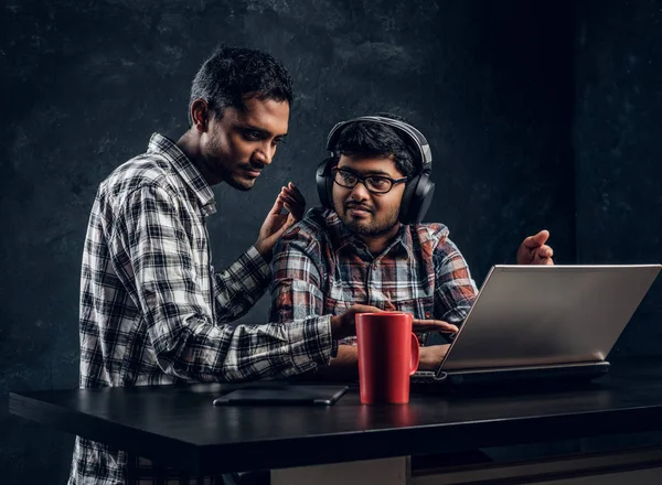 Δύο φίλοι μαθητή Ινδικό που εργάζονται από κοινού για ένα νέο έργο που κάθεται στο τραπέζι με ένα φορητό υπολογιστή — Φωτογραφία Αρχείου