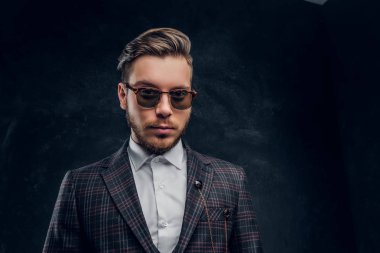 Zarif bir karanlık dokulu duvara güneş gözlüklü genç adam giyinmiş