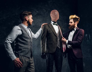 Moda tasarımcısı özel yapılmış erkek takım elbise bir karanlık terzi stüdyoda kontrol bir müşteri ile 
