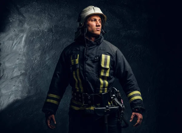 Retrato de bombero vestido con uniforme y casco de seguridad mirando hacia los lados con una mirada segura — Foto de Stock