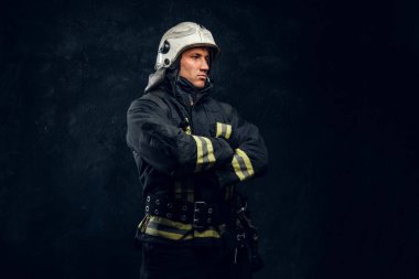 Kask içinde erkeksi itfaiyeci yana doğru görünüyor