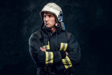 Çapraz kol ve kendinden emin bir görünüm ile kamera ayakta için poz üniformalı acımasız itfaiyeci.