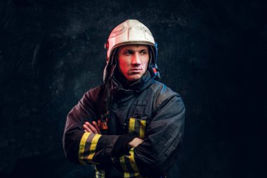 Çapraz kol ve kendinden emin bir görünüm ile kamera ayakta için poz üniformalı acımasız itfaiyeci.