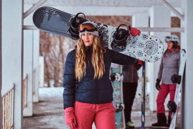 Sıcak giysiler ve snowboard kış kayak tatil ile poz gözlük giyen Norveçli kadın