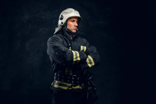 Manly firefighter in helmet looks sideways