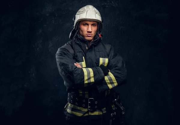 Manly firefighter in helmet looks into camera