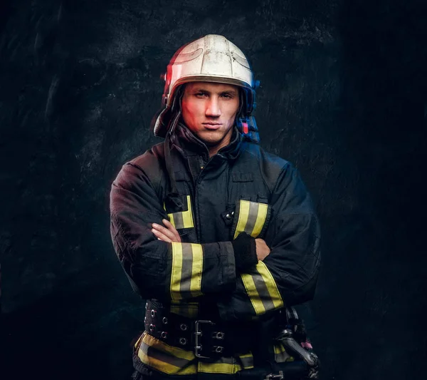 Brutal fireman in uniform posing for the camera standing with crossed arms and confident look. — Stock Photo, Image