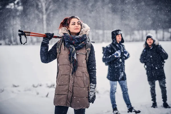 Uma empresa amigável viajando na floresta de neve . — Fotografia de Stock