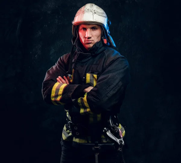Brutális tűzoltó-egyenruhában pózoló a kamera állandó karokkal és magabiztos megjelenés. — Stock Fotó