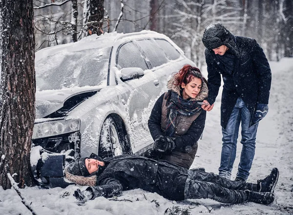 Witness of the accident helps the injured couple to contact the rescue service. — Stock Photo, Image