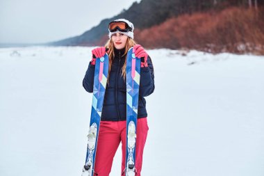 Karlı bir plajda kayaklar ile poz sıcak giysiler giyen Norveçli kadın
