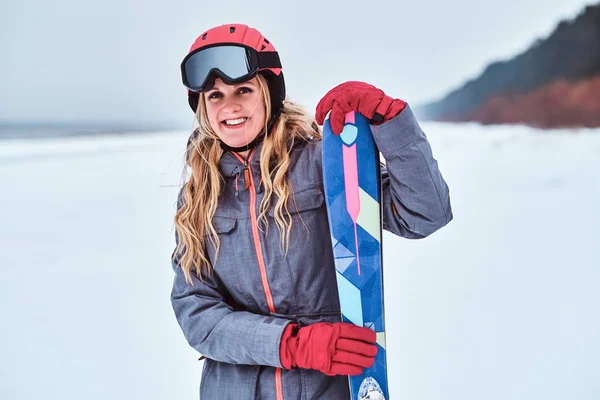 Norský žena nosí teplé oblečení pózuje s lyžemi na zasněžené beach — Stock fotografie