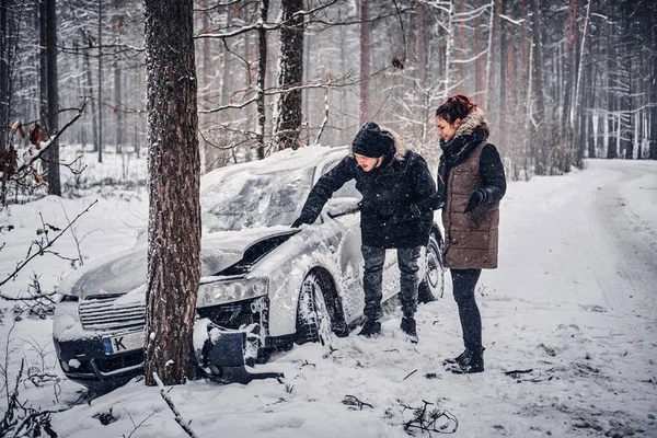 Bilen hamnade i en skid och kraschade in i ett träd på en snöig väg. — Stockfoto