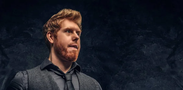 Retrato de um homem ruivo bonito com cabelo elegante e barba em estúdio contra uma parede texturizada escura — Fotografia de Stock