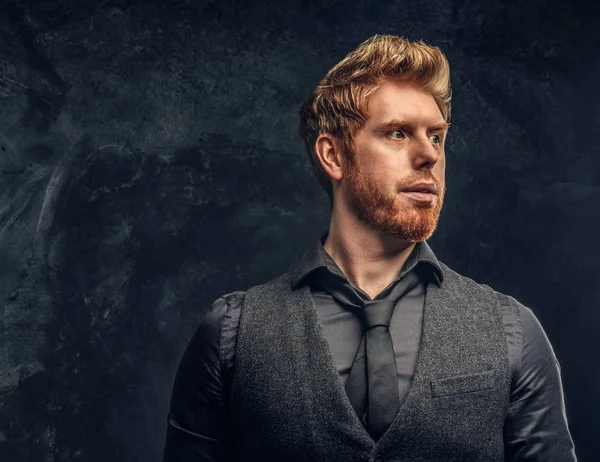 Retrato de un hombre pelirrojo guapo con el pelo elegante y la barba en el estudio contra una pared de textura oscura —  Fotos de Stock