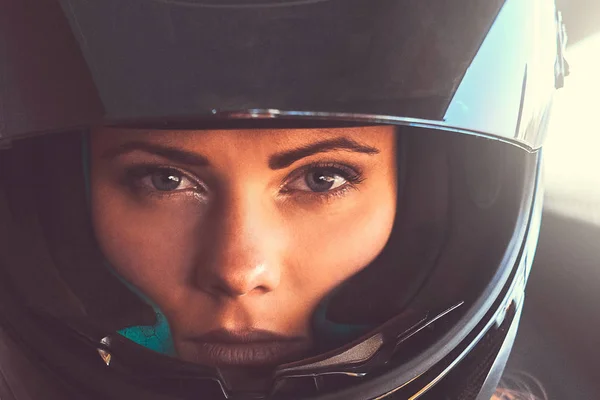 Közelkép a gyönyörű fiatal nő motoros és egy nyitott visor fekete sisakot viselő portréja. — Stock Fotó
