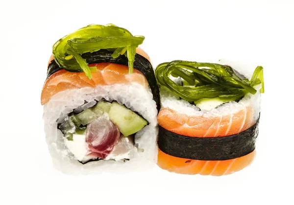 Rotolo giapponese avvolto in una sottile fetta di salmone e guarnito con alghe . — Foto Stock