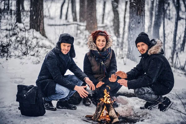 Schüler wärmen sich am Lagerfeuer im Winterwald auf — Stockfoto