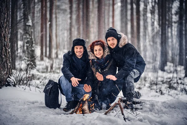 Os alunos se aquecem na fogueira na floresta de inverno — Fotografia de Stock