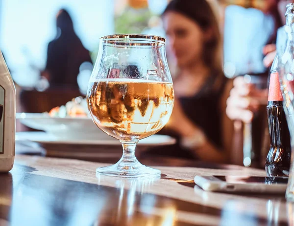 Bicchiere di birra, salsa all'aglio e un telefono sul tavolo nel caffè all'aperto — Foto Stock