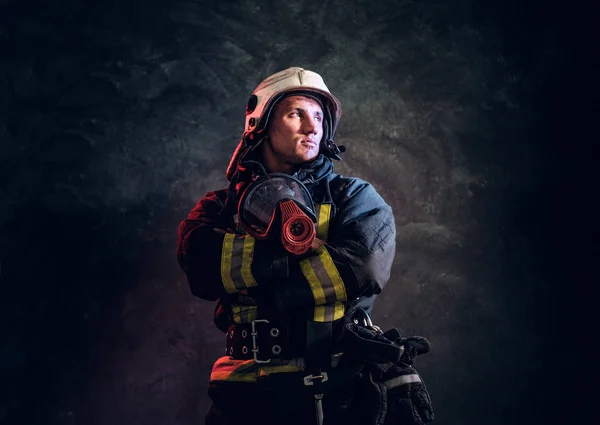 Manly firefighter in helmet looks sideways
