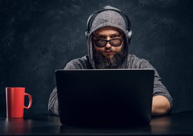 Bir hacker bir dizüstü karanlık bir ofiste arkasına oturur... ve dikkatle kameraya bakıyor