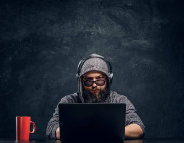 Bir hacker bir dizüstü karanlık bir ofiste arkasına oturur... ve dikkatle kameraya bakıyor
