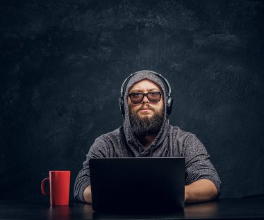 Bir hacker bir dizüstü karanlık bir ofiste arkasına oturur... ve dikkatle kameraya bakıyor