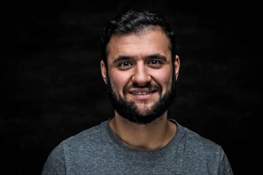 Yakın çekim portre neşeli bir adam, karanlık bir arka plan üzerinde izole sakallı. Stüdyo vurdu