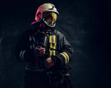 Kask içinde erkeksi itfaiyeci yana doğru görünüyor