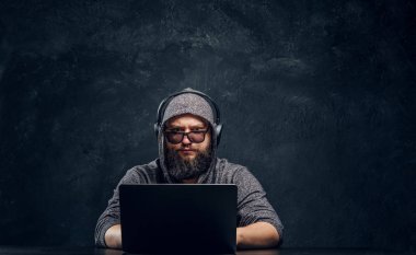 Bir hacker bir dizüstü karanlık bir ofiste arkasına oturur... ve dikkatle kameraya bakıyor